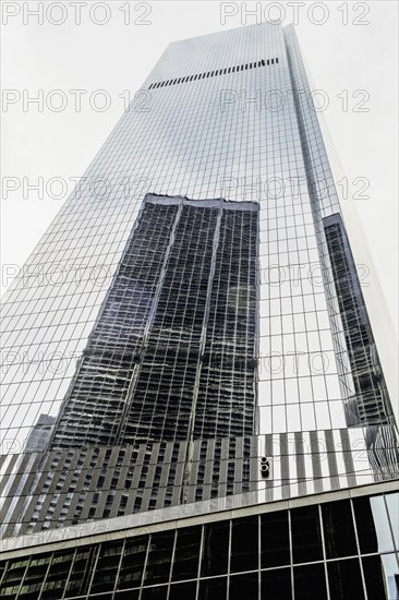 Skyscraper reflected in building windows