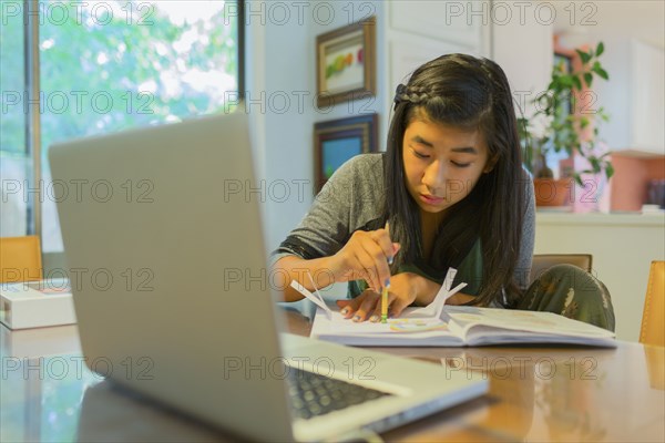 Chinese girl doing homework at table