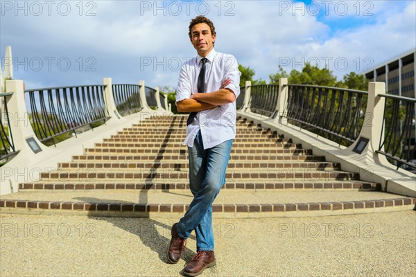 Hispanic businessman standing by urban steps