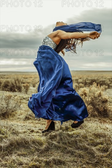 Chinese teenage girl playing with scarf in rural field