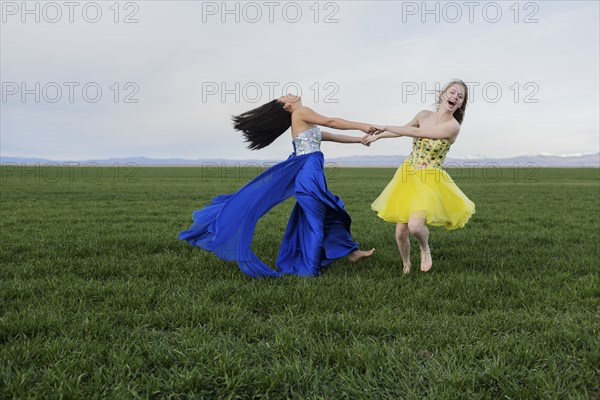 Teenage girls wearing gown in rural field