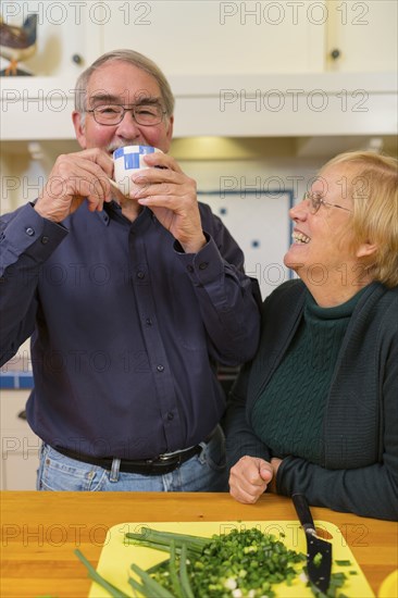 Caucasian couple cooking together in kitchen