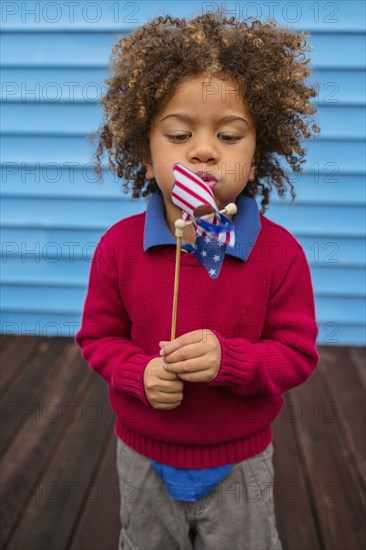 Pacific Islander boy blowing patriotic pinwheel