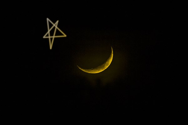 Star drawn by crescent moon in night sky