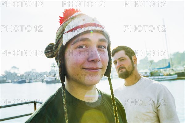 Caucasian boy wearing knitted cap in harbor