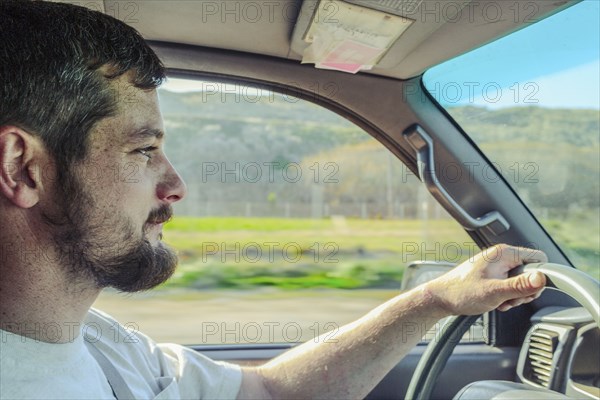 Caucasian man driving car on rural road