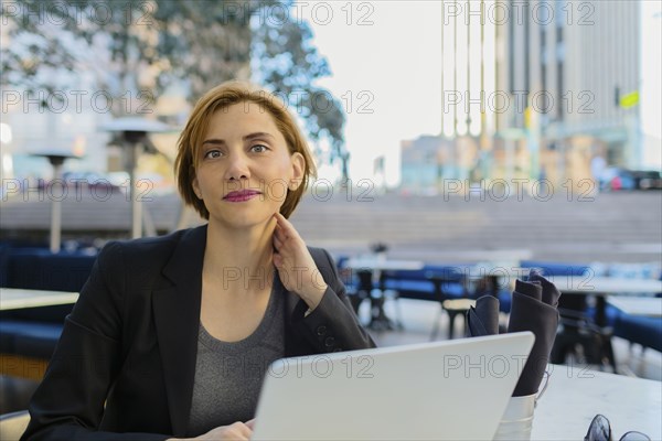 Caucasian businesswoman working at sidewalk cafe