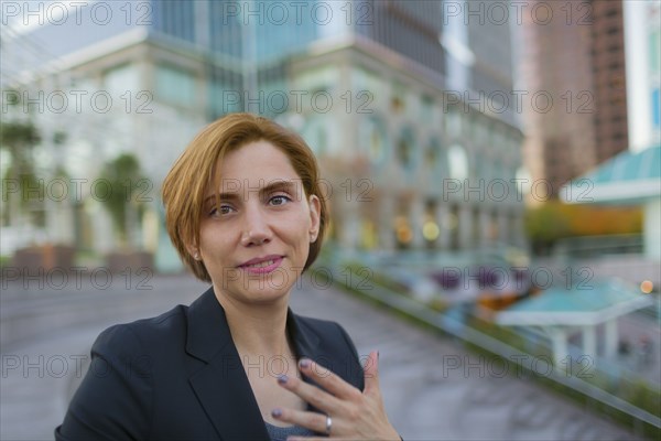 Caucasian businesswoman sitting in city park