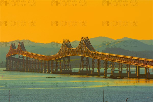 Bridge and river under sunset sky