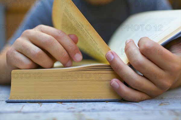 Close up of Hispanic man turning book pages