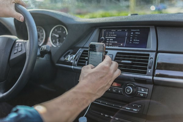 Caucasian man using cell phone and driving car