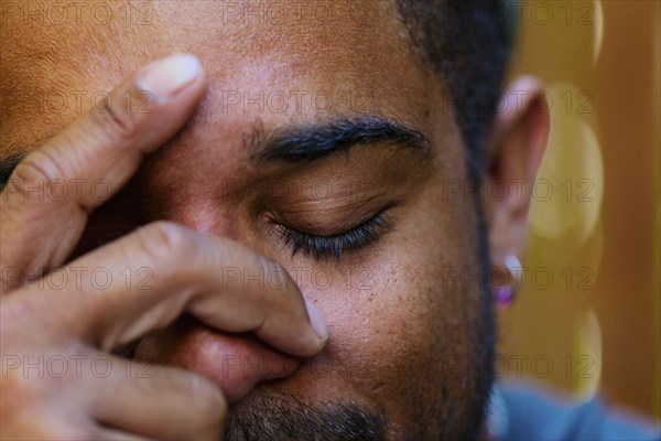 Close up of mixed race man holding head in hands