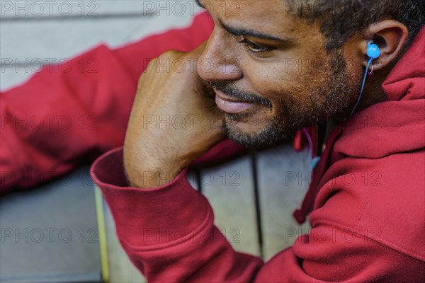 Close up of mixed race man listening to earbud