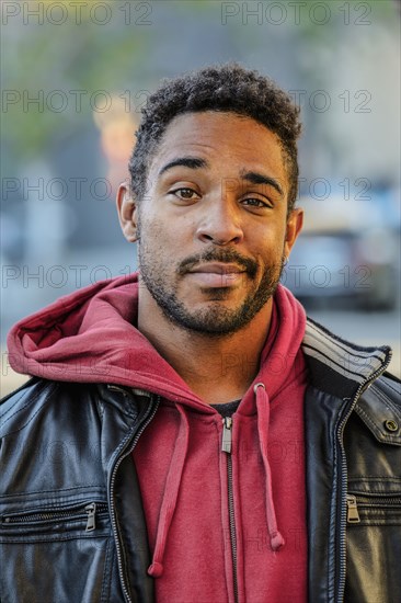 Mixed race man with raised eyebrow standing outdoors