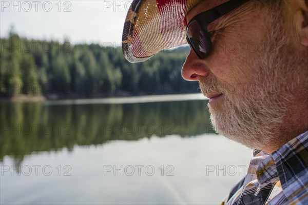 Close up of Caucasian man standing near lake