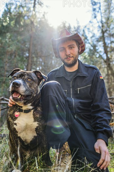 Caucasian man sitting with dog in field