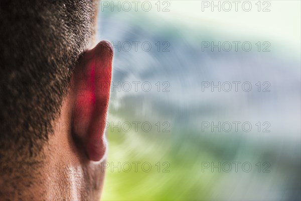 Close up of ear of Caucasian man and sound waves