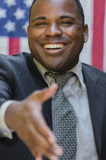 Smiling Black politician offering handshake