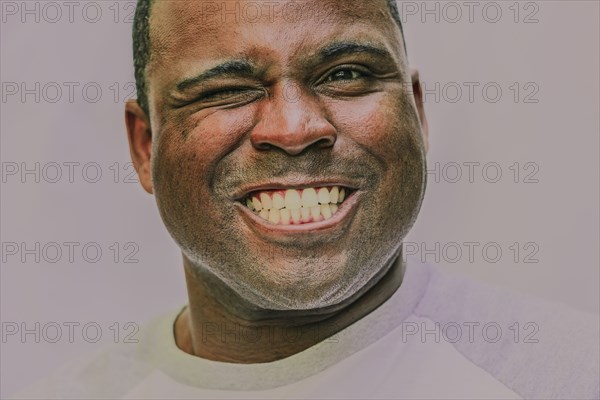 Close up of grinning Black man winking