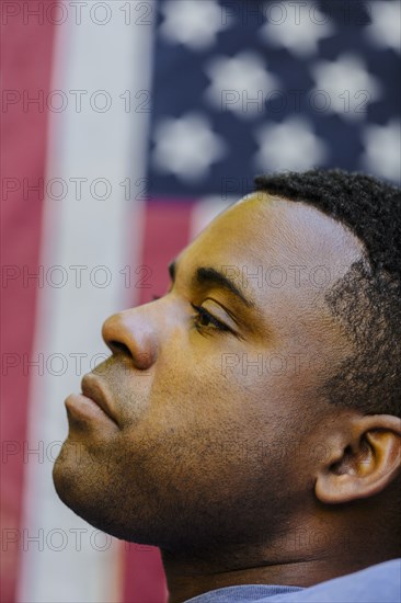 Profile of Black man in front of American flag