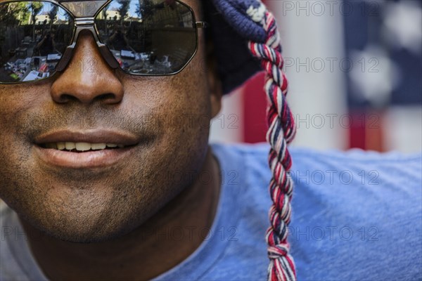 Close up of Black man wearing sunglasses and knit cap