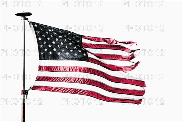 Tattered American flag flying from flagpole