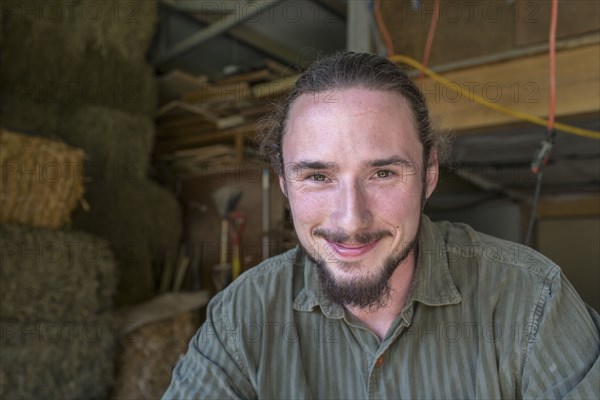 Caucasian farmers smiling in barn