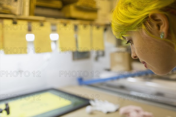 Caucasian artist working in screen print workshop