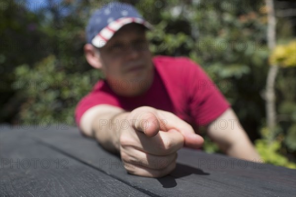 Mixed race man pointing finger on picnic table