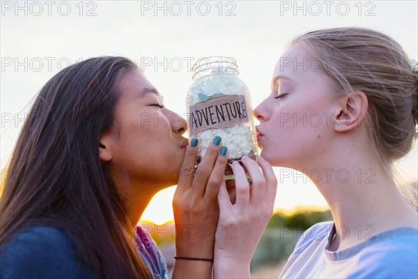 Teenage girls kissing adventure savings jar