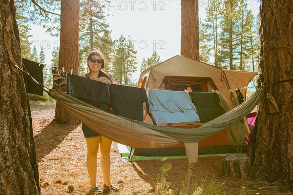 Caucasian woman hanging laundry at campsite