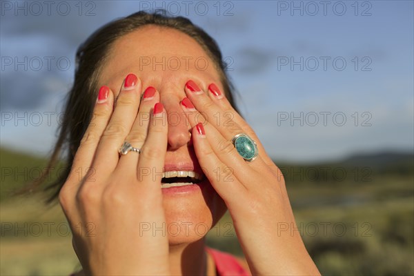 Close up of Caucasian woman covering her eyes