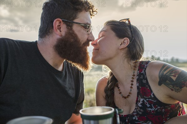 Caucasian couple kissing at picnic table