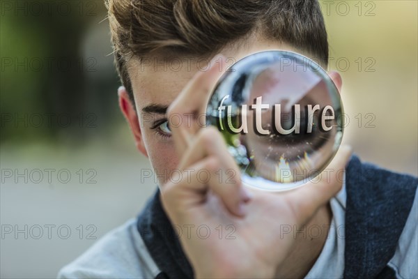 Caucasian teenage boy holding crystal ball