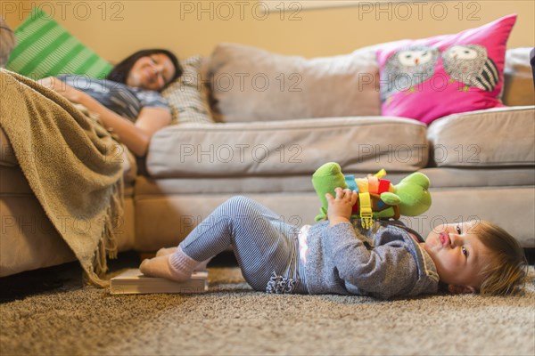 Mother and baby daughter relaxing in living room