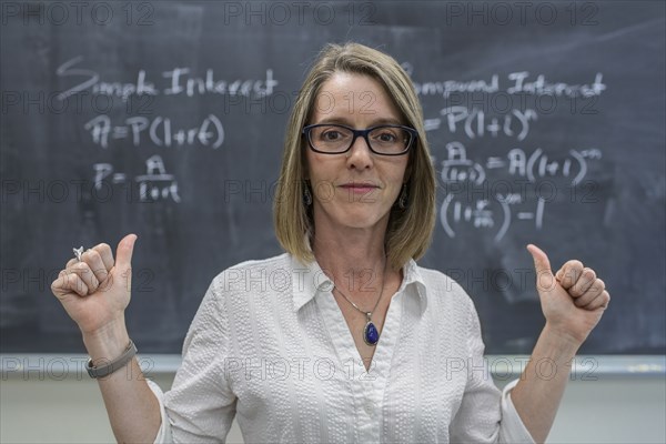 Caucasian teacher cheering at chalkboard