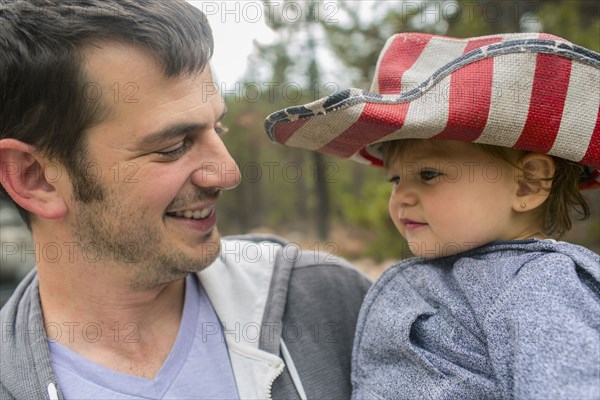 Father carrying daughter in patriotic hat