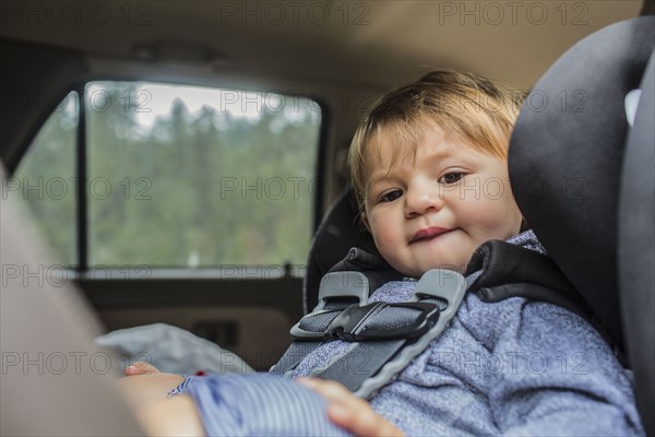 Mixed race girl sitting in car seat