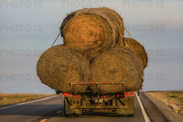 Truck carrying hay bales on rural highway