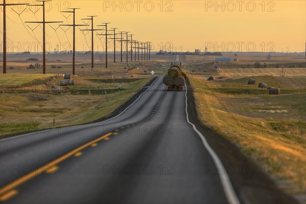 Truck carrying hay bales on rural highway