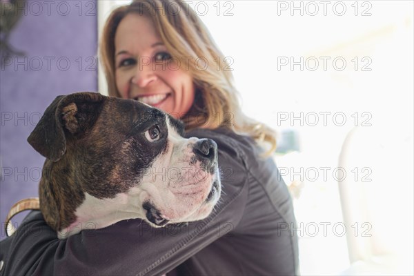 Caucasian woman hugging dog