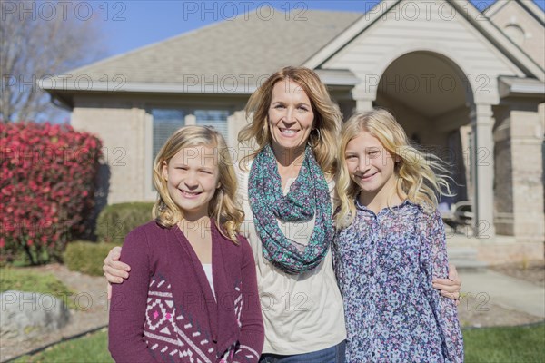 Caucasian mother and daughters smiling in yard