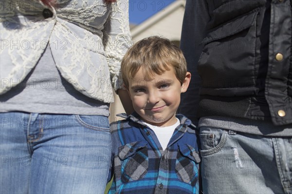 Caucasian parents and son smiling outdoors