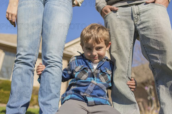 Caucasian parents and son smiling outdoors