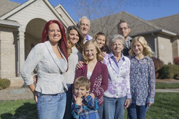 Caucasian multi-generation family smiling in yard