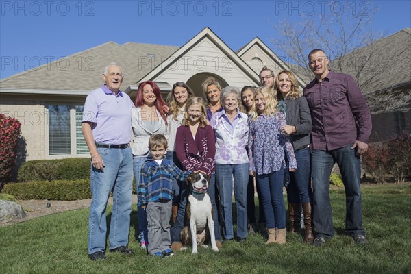 Caucasian multi-generation family smiling in yard