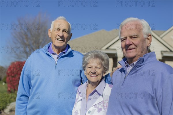 Older Caucasian friends smiling in yard