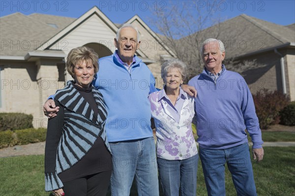 Older Caucasian friends smiling in yard