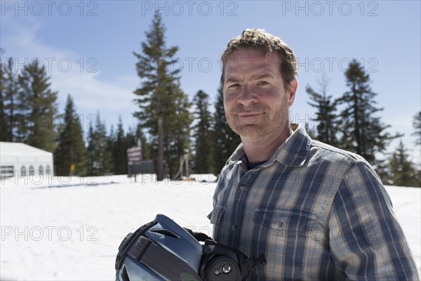 Caucasian man walking on snowy hilltop