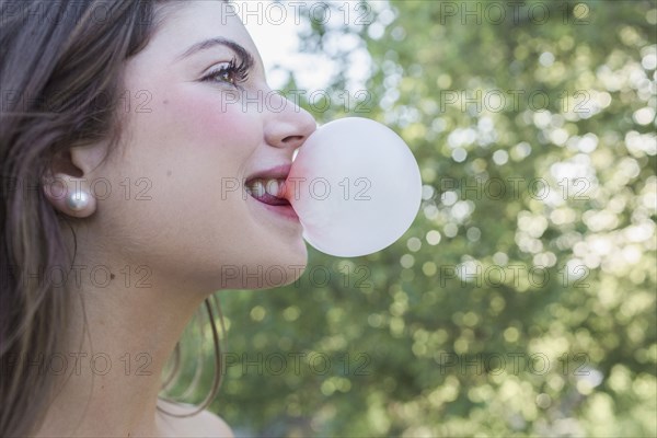 Caucasian girl blowing bubble gum bubble